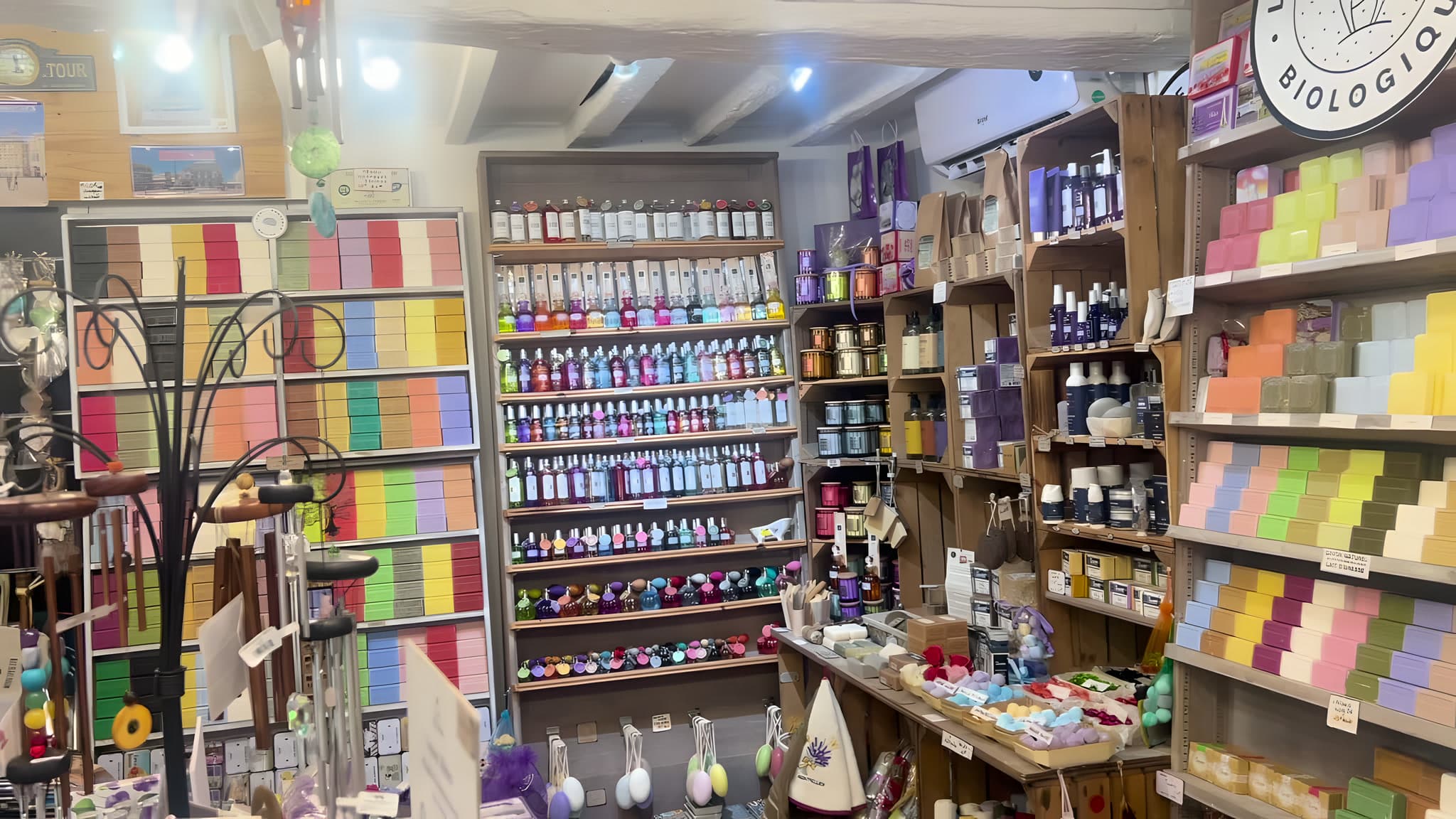 L'intérieur de la boutique : murs de savons colorés, flacons de senteurs et caisses en bois